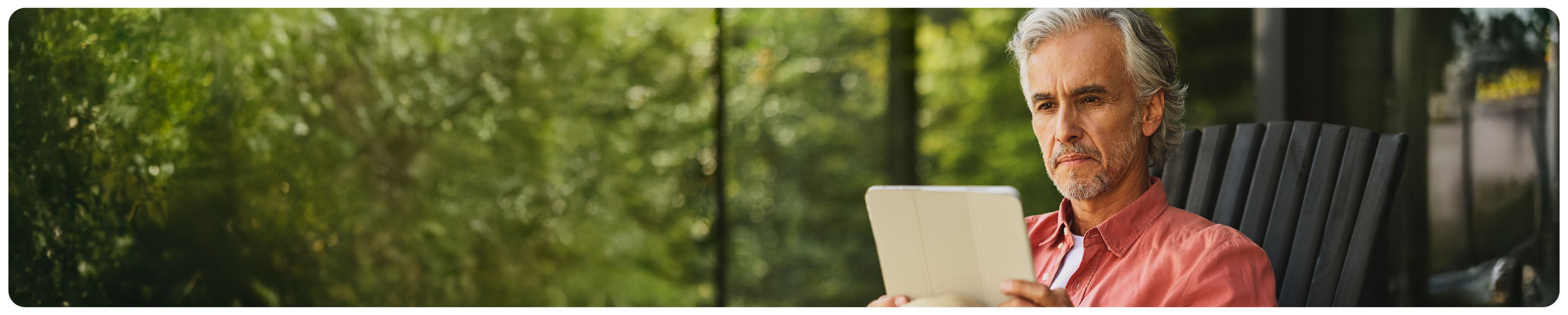 A man sitting in a chair reading a tablet