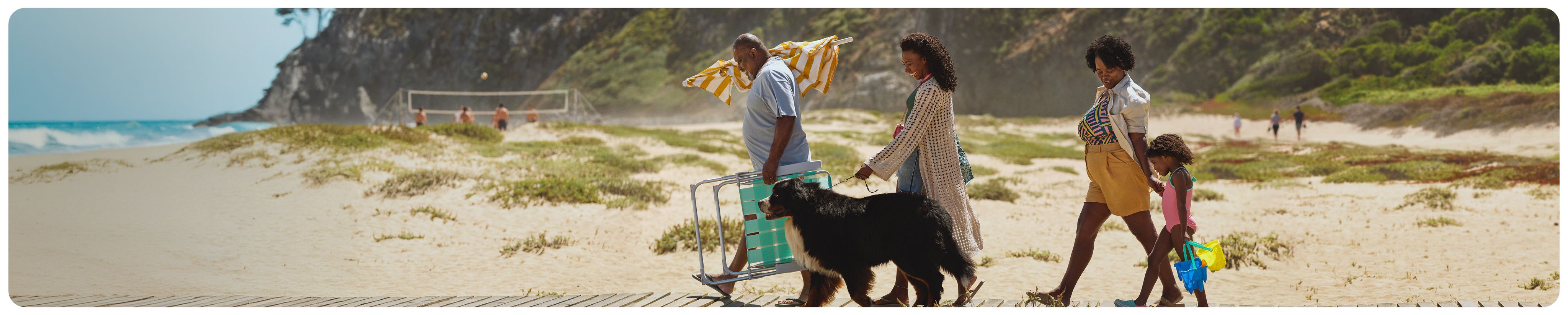 A family and their dog walking together to the beach 