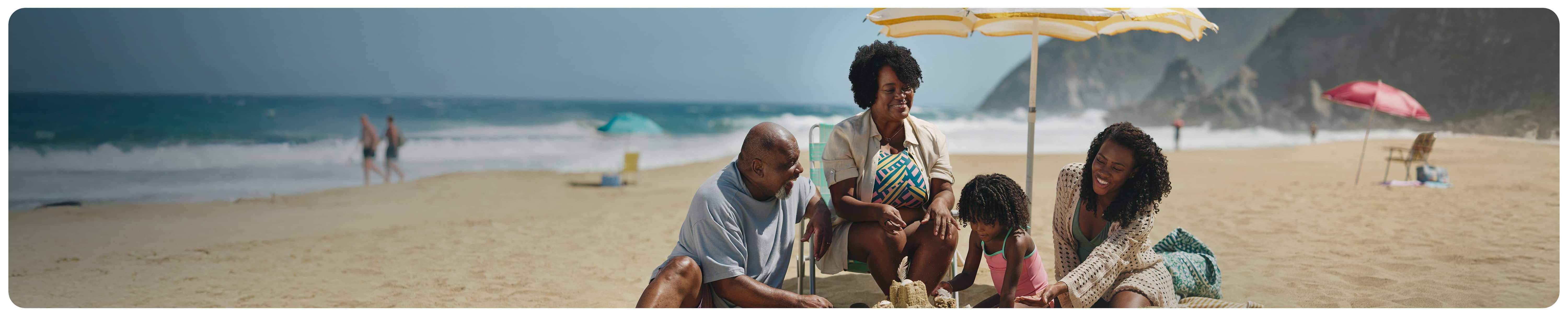 Family sitting together on the beach building a sandcastle